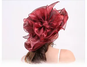 Detail of elegant dark red organza sun hat featuring layered floral ruffles and a wide brim