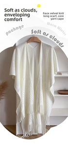Detail of soft cream knitted shawl showing hollow-out texture and long tassel fringe