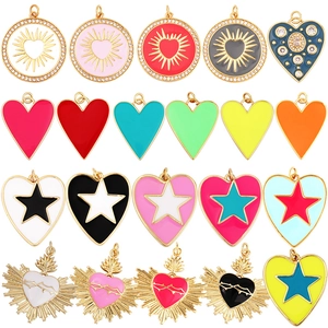 Colorful enamel heart and star zircon pendants arranged in a flat lay display