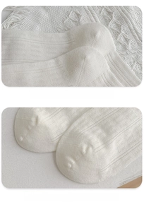 Detail of reinforced heel and toe on white ribbed knit socks with fine stitching