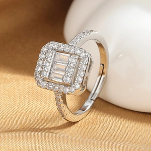 Macro detail of silver queen ring with triple rectangular zircon stones and halo pavé diamonds