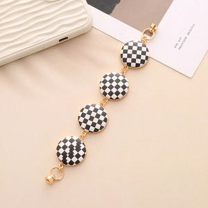 Close-up of black and white checkerboard pattern charm chain with gold metal links