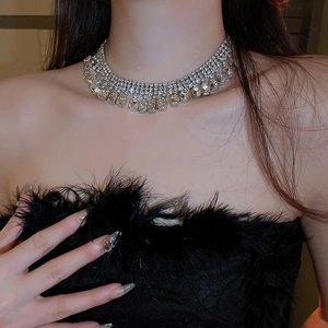 Gros plan d'un collier choker argenté à franges de diamants carrés sur un mannequin