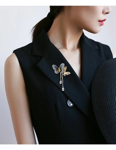 Détail d'une broche papillon avec glands en zircon sur un gilet noir élégant