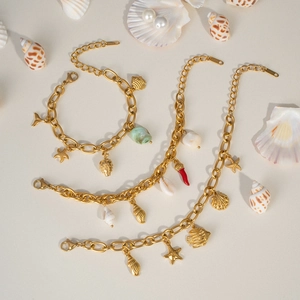 Detailed view of gold ocean-themed bracelets with starfish, shell, and coral charms