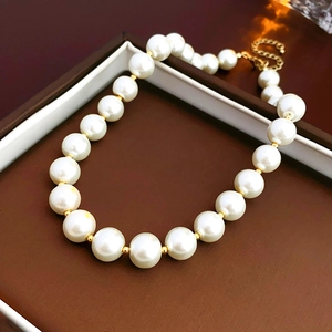 Macro shot of large white round pearls with gold spacers on a jewelry display box