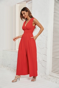Detail of red sleeveless V-neck jumpsuit with waist tie and textured fabric