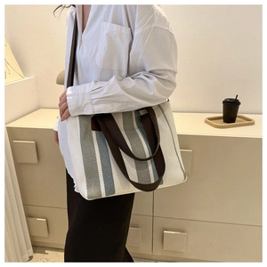 Detail of striped canvas tote bag showing heavy-duty straps and large capacity