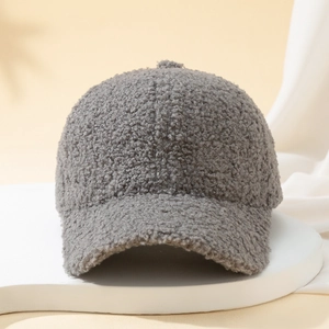 Detailed texture shot of a dark grey teddy fleece baseball cap on a white platform