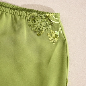 Detailed view of green backless dress featuring intricate sequin floral embroidery