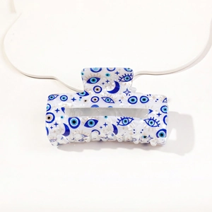 Detail of white marble PVC hair claw clip with blue evil eye and celestial patterns