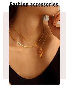 Nahaufnahme von 18k Gold-Muschelanhänger mit Perle auf einer doppellagigen Schlangenkette