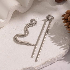 Détail de boucles d'oreilles pendantes en chaîne serpent argentée avec design noué