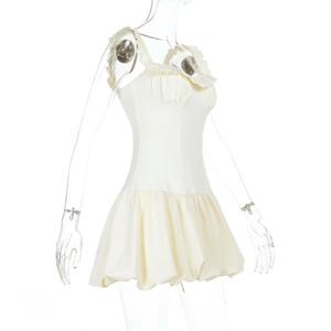 Detailed view of ruffle neckline and bubble hem on cream sleeveless mini dress
