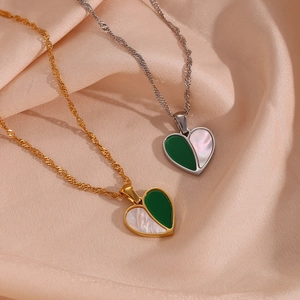 Detail of gold and silver heart pendants with shell inlay on champagne silk background