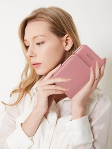 Pink large capacity long zipper wallet in faux leather held by hands for size reference