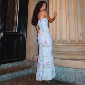 Detail of a low back floral maxi dress with side slit and delicate strap design