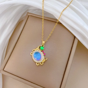 Macro shot of colorful crab pendant with blue crystals on a beige display stand