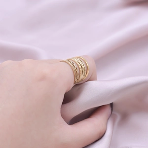Close-up of gold stainless steel stackable ring set with twisted and wave textures