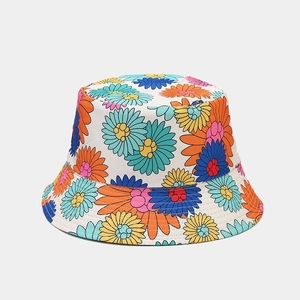 Détail du motif floral coloré sur le chapeau de soleil en coton blanc avec surpiqûres