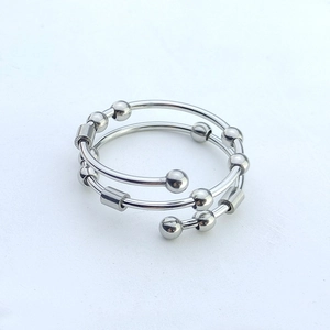Macro detail of silver stainless steel fidget ring with rotatable beads and spiral design