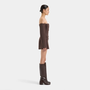 Detail shot of a dark brown off-shoulder mini dress featuring side buttons and pocket detail