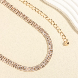 Détail d'un collier ras du cou doré à plusieurs rangées de strass avec chaîne réglable