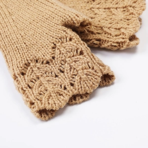 Detail of camel knit fingerless gloves showing delicate hollow lace crochet texture