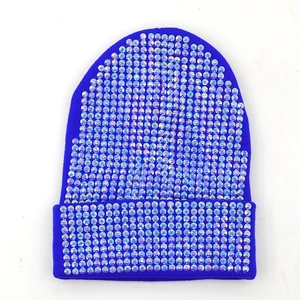 Dettaglio del berretto in maglia blu reale con strass colorati e ampio bordo risvoltato