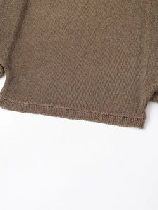 Détail de l'ourlet du pull marron montrant la texture de maille et le tissage fin