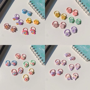 Close-up of cute fruit and rainbow resin charms on elastic hair ties for girls
