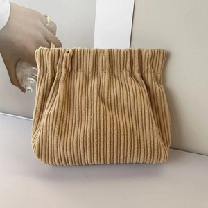 Detail of beige corduroy cosmetic pouch with soft vertical texture and spring closure