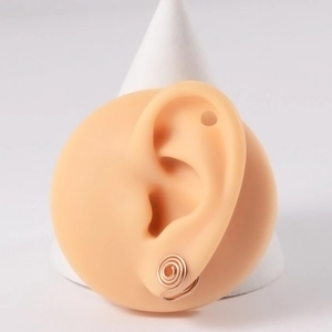 Detailed close-up of rose gold spiral clip-on earring shown on a realistic ear model