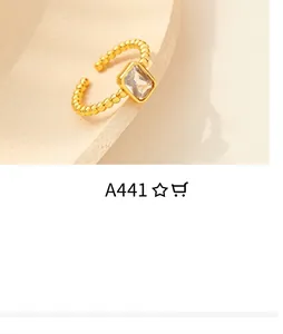 Detail of a gold adjustable ring featuring a beaded band and a rectangular clear zircon stone