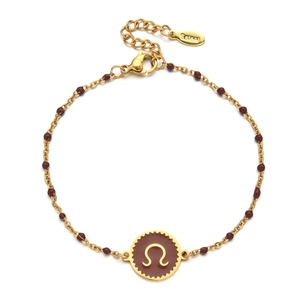 Detailed macro view of a gold stainless steel beaded bracelet with a brown zodiac charm