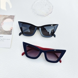 Stylish cat-eye blue light blocking glasses in black and navy red on a stone background