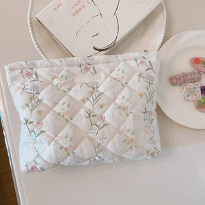 Macro detail of quilted cotton makeup bag with floral print and simple wish label