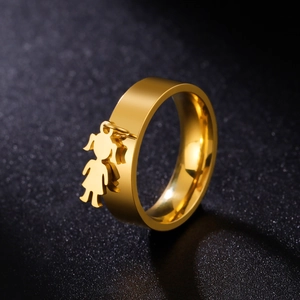 Close-up of golden stainless steel wide ring featuring a delicate girl charm pendant