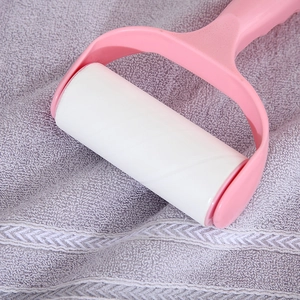 Rullo levapelucchi rosa per peli di animali su asciugamano grigio con impugnatura ergonomica