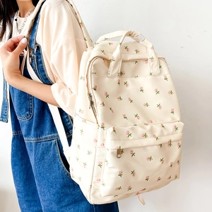Detailed side view of floral backpack with pink rose patterns on beige fabric
