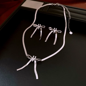 Close-up of zircon bow necklace and earrings set in a premium black leather jewelry gift box