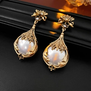 Vue macro de boucles d'oreilles fleurs dorées vintage avec perles blanches et diamants