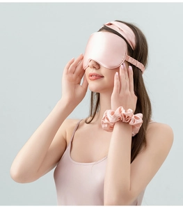 Close-up of pink 22 momme silk sleep set featuring eye mask, headband and scrunchie