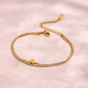 Detail of double-layer gold heart bracelet with sparkling cubic zirconia tennis chain