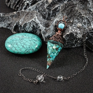 Macro view of a conical crystal resin pendant with copper filigree and turquoise beads