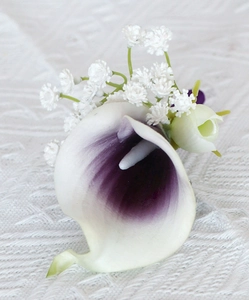 Close-up of elegant calla lily boutonniere with baby's breath and rosebud decor