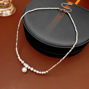 Detail of silver beaded necklace with white pearls and sparkling crystal pendant