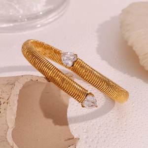 Detail of 18K gold plated spiral cuff bracelet featuring twin heart cubic zirconia stones
