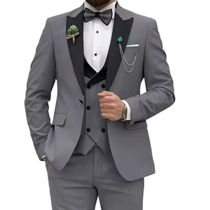 Detail of grey men's three-piece suit with black peak lapels and decorative chain brooch