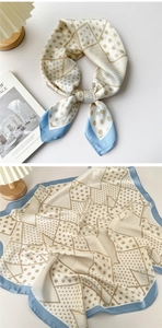 Detail of light blue geometric polka dot silk scarf draped next to a wooden lamp